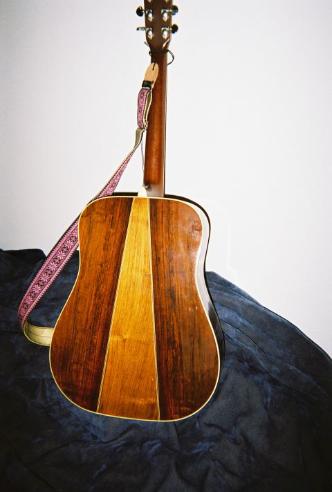 1972 Ford Ranchero - Acoustic guitar with a dark blue cloth and a pink patterned strap.