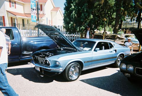 1972 Ford Ranchero - A light blue 1969 Ford Mustang Mach 1 is displayed with its hood open at a car show, alongside other vehicles.