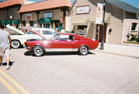 1972 Ford Ranchero - A red 1967 Shelby GT500 is displayed with its hood open, alongside another vehicle.