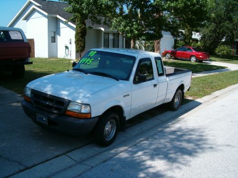 1991 Ford Bronco - A white Ford Ranger pickup truck is parked on the street in front of a house, with a red car visible in the driveway.