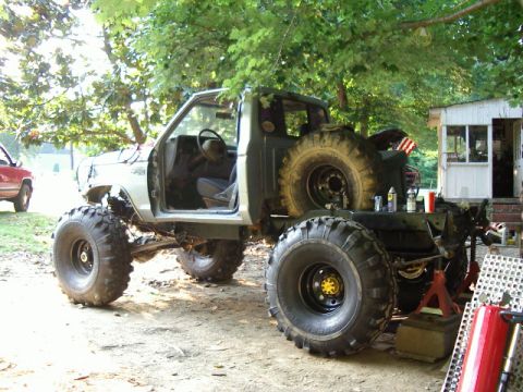 1985 Ford Bronco - A heavily modified pickup truck sits outdoors with a second vehicle visible in the background.