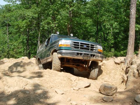 1995 Ford Bronco - This Ford Bronco is tackling a challenging off-road course with steep inclines and large rocks.