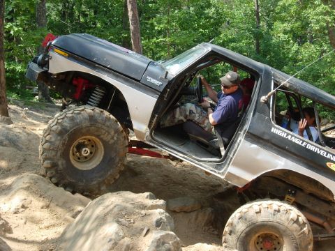 1995 Ford Bronco - Modified Ford Bronco navigating a rocky off-road course with occupants inside.