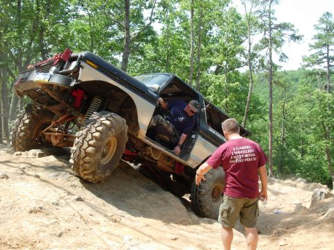 1995 Ford Bronco - This heavily modified Ford Bronco is tackling a steep, sandy incline during an off-road event.