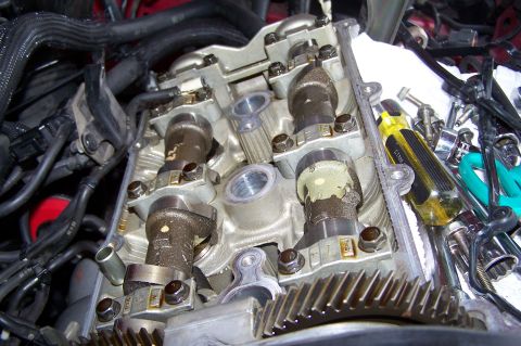 1997 Ford Probe - Close-up of an engine's internal components with the valve cover removed, tools nearby.