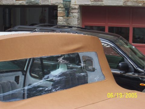 1979 Ford Bronco - Close-up of a tan soft top with a black SUV partially visible in the background.
