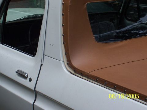 1979 Ford Bronco - Close-up of a white pickup truck's door and soft top, showing the interior and a date stamp.