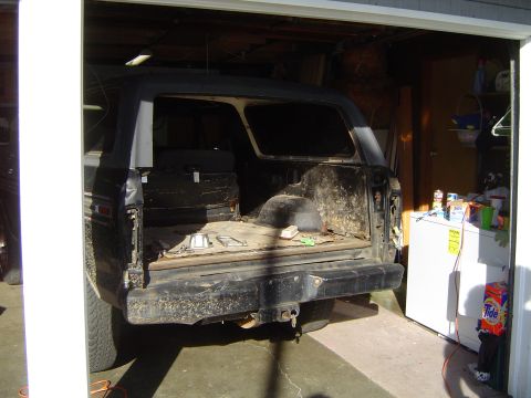 1979 Ford Bronco - Rear view of a 1979 Ford Bronco in a garage, showing its open cargo area.