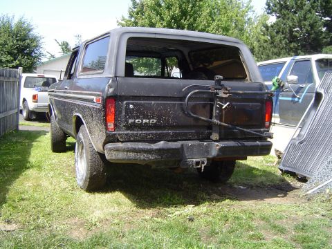 1979 Ford Bronco - Rear view of a black Ford Bronco, parked outdoors with another vehicle nearby.
