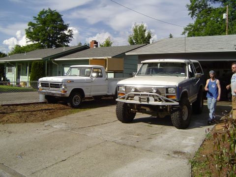 1979 Ford Bronco - A lifted 1979 Ford Bronco with a custom bumper is parked in a driveway next to a white pickup truck.