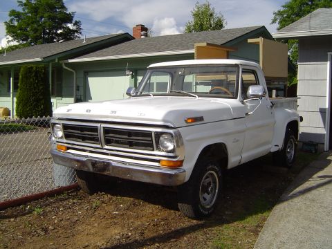 1979 Ford Bronco - A white Ford pickup truck is parked in front of a residential garage.