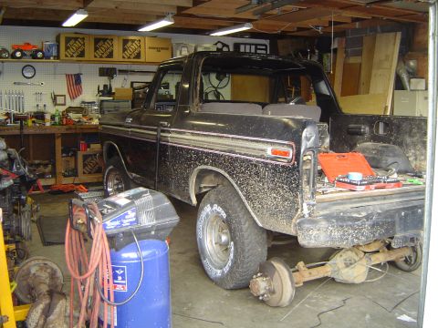 1979 Ford Bronco - Ford Bronco undergoing repairs in a workshop, with its rear axle detached.