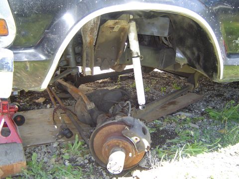 1979 Ford Bronco - Disassembled vehicle suspension and brake components are visible, with a shock absorber and fender section.