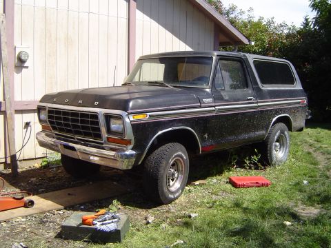 1979 Ford Bronco - A black 1978 Ford Bronco sits outside a building, with tools and a red toolbox nearby.