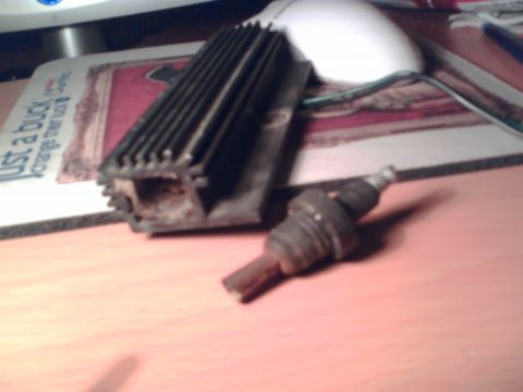 1997 Ford Probe - A spark plug and a heat sink are displayed on a desk, with a computer mouse and mousepad in the background.