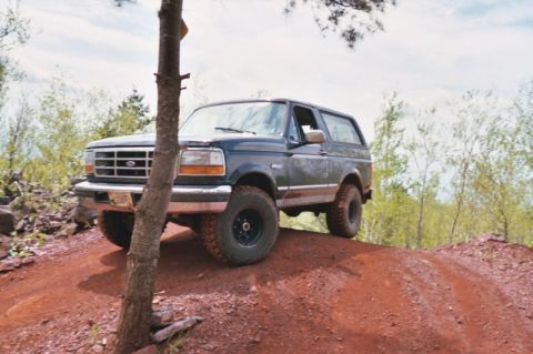 1996 Ford Bronco - This 1996 Ford Bronco navigates a challenging dirt incline, its off-road capabilities.