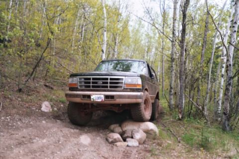 1996 Ford Bronco - This Ford Bronco is navigating a rocky path through a wooded area.