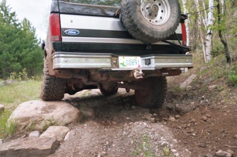 1996 Ford Bronco - This Ford Bronco is navigating a rocky trail, with its rear tire on a large boulder.