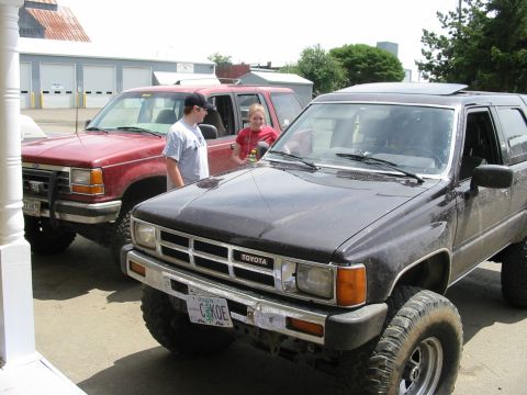 1991 Ford Explorer - Two SUVs, a Toyota and a Ford, are parked in front of some buildings.