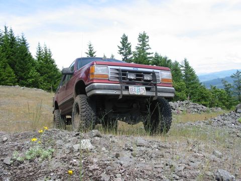 1991 Ford Explorer - This lifted 1991 Ford Explorer navigates a , rocky trail surrounded by trees.