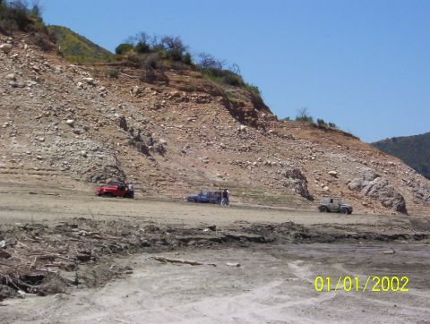 1985 Ford Bronco - Several off-road vehicles are parked on a dry, rocky slope with a date stamp of 01/01/2002 visible.