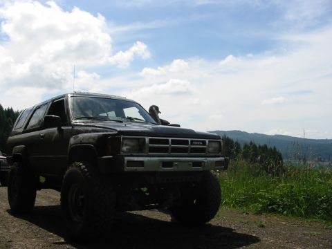 1991 Ford Explorer - This modified Toyota 4Runner is parked on a dirt road with a scenic view of hills and trees.