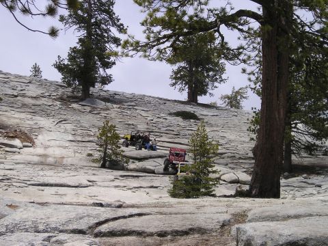 1989 Ford Bronco - Two off-road vehicles navigate a vast, rocky landscape under a cloudy sky.