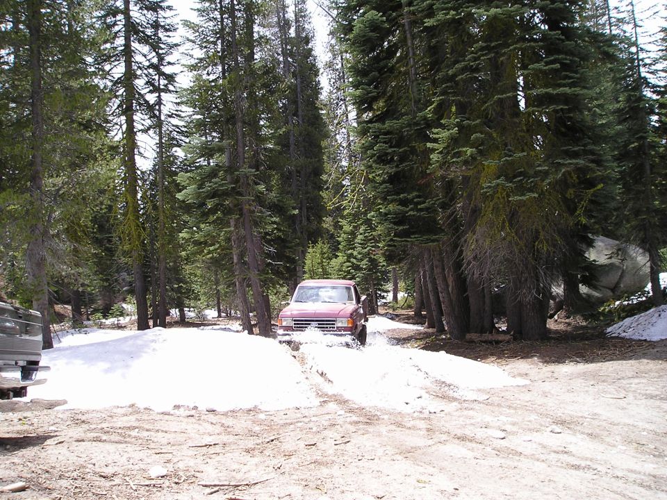 Red SUV driving through snow, 1987 grille visible