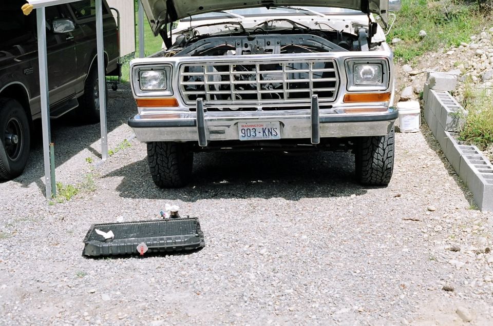 1979 Ford Bronco front view, hood open, with a removed radiator on the ground
