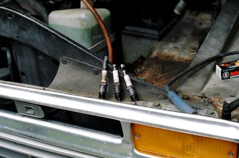 1979 Ford Bronco - The engine bay of a 1979 Ford Bronco shows three spark plugs and a Supermotors.net logo.