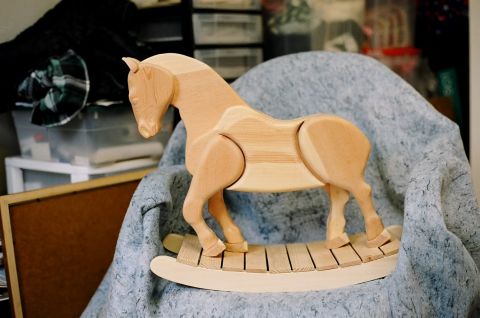 1979 Ford Bronco - A wooden rocking horse is placed on a chair covered with a blue blanket.