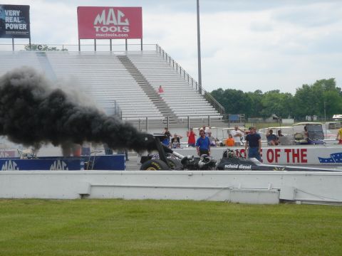2003 Dodge 3500 - Dragster emits black smoke during a race event at a drag strip.