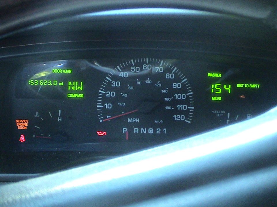 Lit instrument cluster showing 153,623 miles, compass NW, PRND21, speedometer to 120