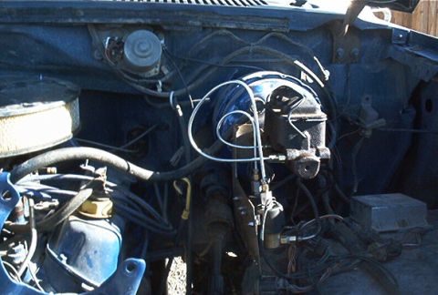 1986 Ford Bronco - The engine bay of a vehicle, the brake master cylinder and air intake system.