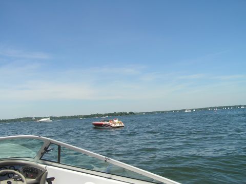 1997 Crownline 266 CCR - Boats gathered on a lake under a clear blue sky on a sunny day.
