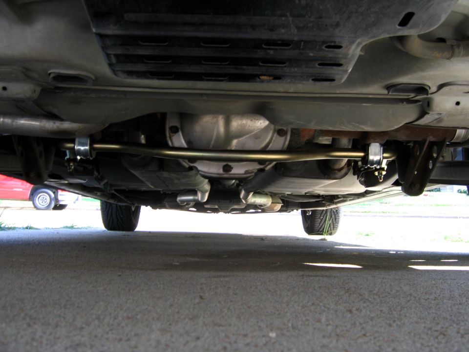 Underbody view of rear sway bar installed on a car's rear axle and frame brackets
