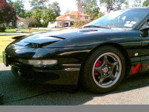 1997 Ford Probe - Front driver's side view of a black 1997 Ford Probe, showing the wheel and fender.