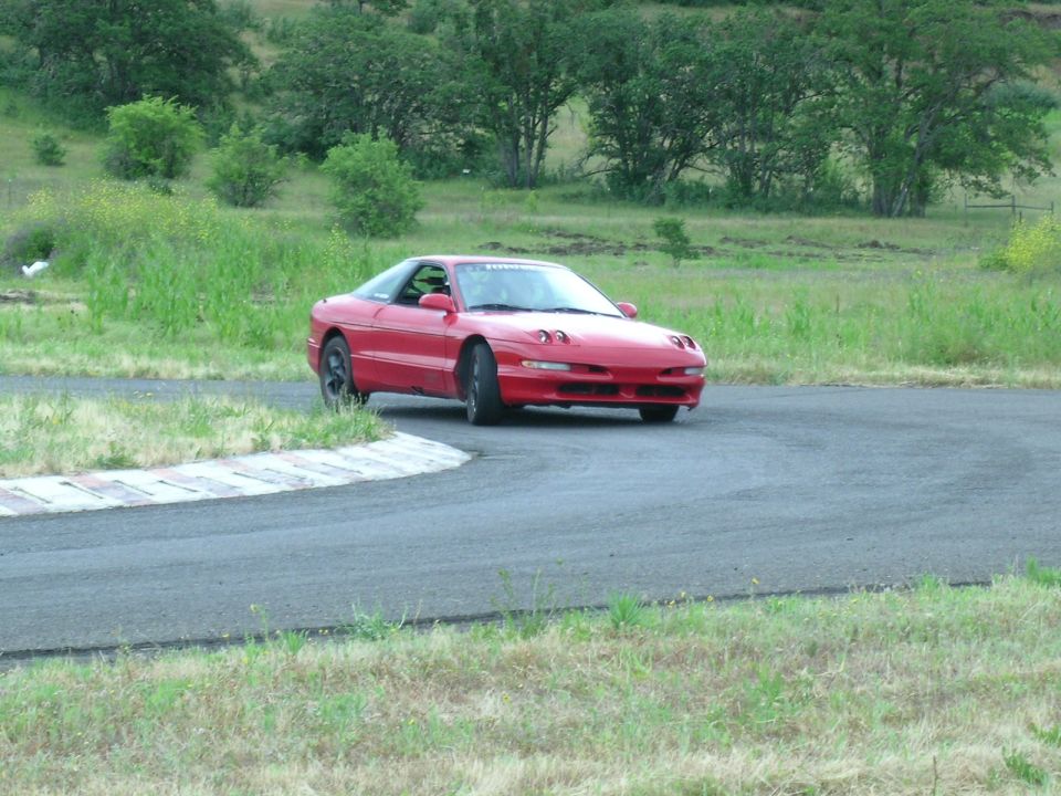 red 1993 Ford Probe on a race track, turning a corner