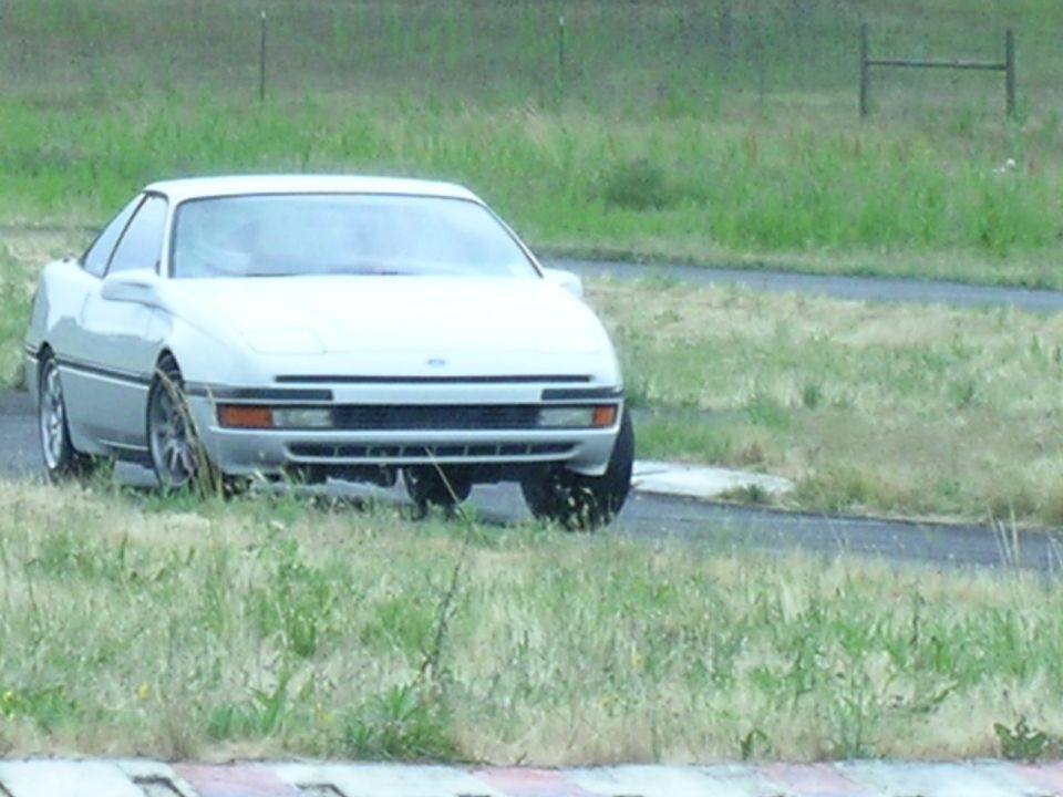 1993 Ford Probe parked on grass next to a track