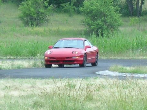 1993 Ford Probe - A red 1993 Ford Probe navigates a turn on a race track.