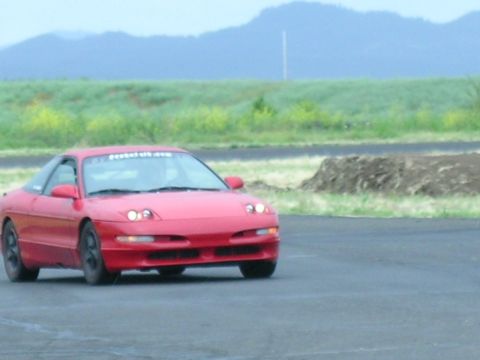 1993 Ford Probe - A red 1993 Ford Probe is seen on a race track, with a banner across the windshield.