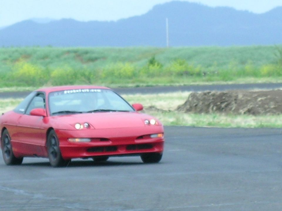 Red 1993 Ford Probe on race track