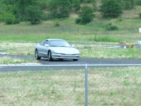 1993 Ford Probe - Silver 1993 Ford Probe driving on a paved track with grassy hills in the background.