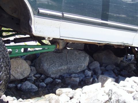 1979 Ford Bronco - Close-up of a vehicle's suspension system navigating rocky terrain.