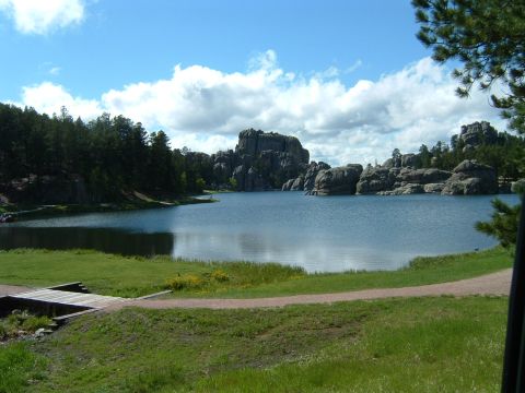 1992 Ford Probe - A scenic view of a lake surrounded by trees and distinctive rock formations on a partly cloudy day.