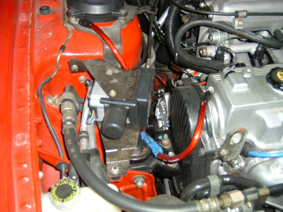 Engine bay close-up with belt, pulleys, hoses, and power steering fluid cap