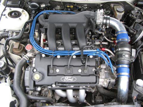 1993 Ford Probe - The engine bay features a Ford engine with prominent blue spark plug wires and a silver intake system.