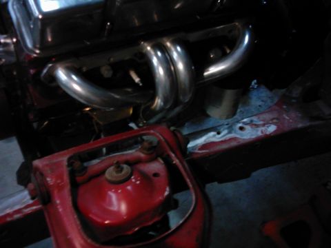 1978 Ford Bronco - Close-up view of engine exhaust headers and a red painted suspension component.