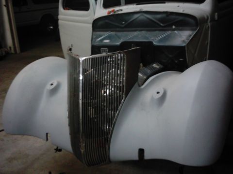 1978 Ford Bronco - A vintage car's front end, including fenders and grille, is shown in primer during restoration.