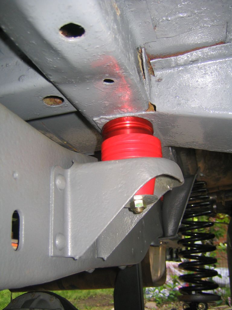 Undercarriage with red poly bump stop on gray-painted frame and black coil spring